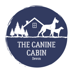 Logo of two dogs outside a cabin the woods.